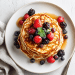 banana cottage cheese pancakes on plate with berries