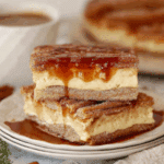 Sliced churro cheesecake bars with caramel drizzle