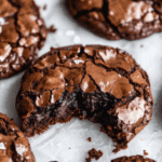 Chocolate brownie cookies with crackly tops on a wooden board