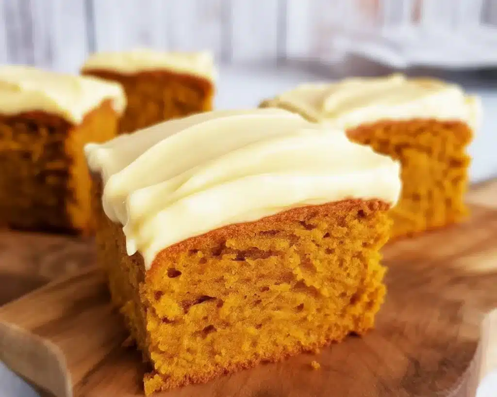Moist Pumpkin Spice Cake topped with cream cheese frosting for a cozy fall dessert.